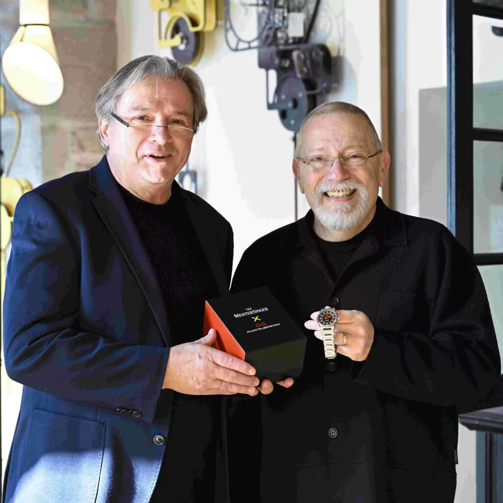 MeisterSinger創業者 Manfred Brassler 氏とデザイナー Alain Silberstein 氏が並んで写るコラボレーション記念ポートレート画像